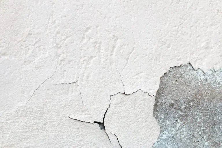 Modern bathroom with a freestanding bathtub, double vanity, large mirror, and tiled walls under bright overhead lighting.