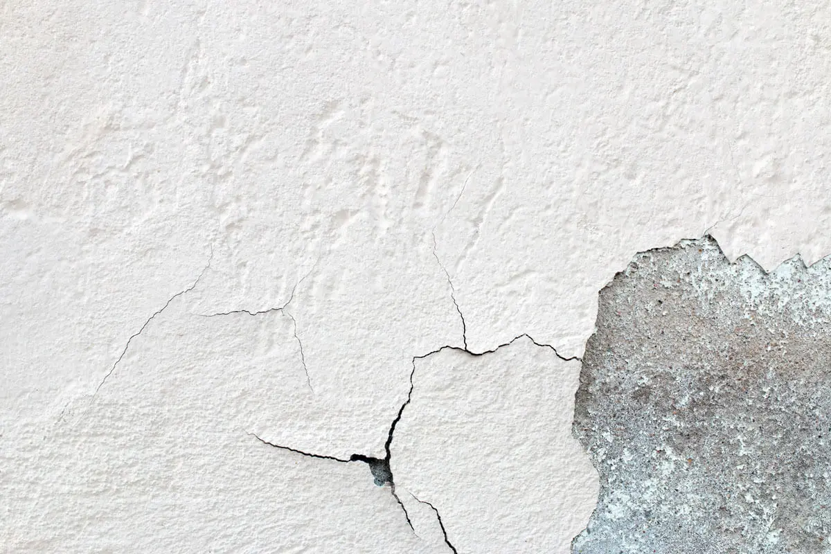 Modern bathroom with a freestanding bathtub, double vanity, large mirror, and tiled walls under bright overhead lighting.
